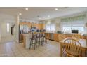 Well-lit kitchen with stainless steel appliances, a breakfast bar, and an adjacent dining area at 29922 N Little Leaf Dr, San Tan Valley, AZ 85143