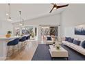 Open-concept living space with kitchen island seating and sliding doors to backyard patio at 2390 S Walnut Dr, Chandler, AZ 85286