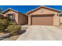 Tan stucco home with well-kept landscaping and a long driveway leading to the attached two-car garage at 22882 E Marsh Rd, Queen Creek, AZ 85142