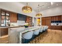 Modern kitchen boasts marble counters, custom cabinets, pendant lighting, and a large center island at 36323 N 100Th Way, Scottsdale, AZ 85262