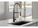 Modern kitchen sink featuring a stylish faucet and a bright view out the window at 18180 W Pima St, Goodyear, AZ 85338