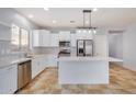 Modern kitchen with white cabinets, stainless steel appliances, and an island at 42356 W Balsa Dr, Maricopa, AZ 85138