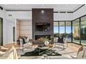 Chic living room featuring a modern fireplace, stylish furniture, and floor to ceiling windows at 40575 N 109Th Pl, Scottsdale, AZ 85262