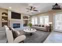 Bright living room featuring a fireplace, ceiling fan, and an abundance of natural light at 17724 W Ocotillo Ave, Goodyear, AZ 85338