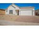 Charming house featuring a white exterior, gray shutters, and a brick driveway at 16430 W Desert Mirage Dr, Surprise, AZ 85388