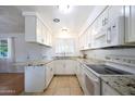 L-shaped kitchen with granite countertops and white cabinets at 4833 N 69Th Dr, Phoenix, AZ 85033