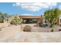 Exterior of home featuring desert landscaping, stone accents, and a circular, modern design at 9853 E Sundance Trl, Scottsdale, AZ 85262