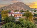 Desert home featuring a pristine pool, solar panels, red tile roof, and mountain views at 10721 E La Junta Rd, Scottsdale, AZ 85255