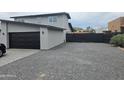 Contemporary two-story home featuring sleek gray siding and a black garage door at 6134 S Borego Rd, Gold Canyon, AZ 85118