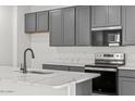 The gourmet kitchen features modern appliances, ample cabinet space and white countertops at 18174 W Pima St, Goodyear, AZ 85338