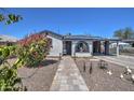 Charming home featuring a stone pathway leading to an arched front porch at 2124 W Maricopa St, Phoenix, AZ 85009