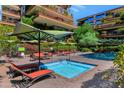 A beautiful pool area with lounge chairs, umbrellas, and greenery at 7117 E Rancho Vista Dr # 4006, Scottsdale, AZ 85251