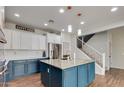 Modern kitchen with blue cabinets, granite island, and stainless steel appliances at 20747 W Alsap Rd, Buckeye, AZ 85396