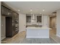 Modern kitchen with dark wood cabinets, stainless steel appliances, a stylish backsplash, and a center island at 31969 N 117Th Ave, Peoria, AZ 85383