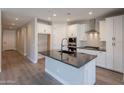 Modern kitchen featuring white cabinetry, an island with a black countertop, and stainless steel appliances at 31985 N 117Th Ave, Peoria, AZ 85383