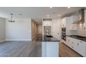 Bright kitchen featuring an island with a black countertop, stainless steel appliances, and an adjacent living area at 31985 N 117Th Ave, Peoria, AZ 85383