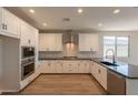 Bright kitchen with white cabinets, granite countertops, stainless steel appliances, and modern fixtures at 32018 N 117Th Ave, Peoria, AZ 85383