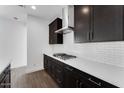 Kitchen showcasing sleek dark cabinets, a stainless steel range hood, and quartz countertops at 1329 W Via De Olivos Dr, San Tan Valley, AZ 85140