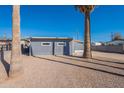 Exterior view of a blue home featuring a desert landscaped yard with palm trees at 7508 W Osborn Rd, Phoenix, AZ 85033