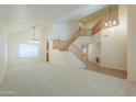 Spacious living room with vaulted ceilings, cozy carpet, and an open staircase at 695 W Estrella Dr, Gilbert, AZ 85233