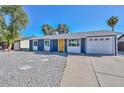 A charming single-story blue home with a bright yellow front door and low-maintenance landscaping at 3801 E Captain Dreyfus Ave, Phoenix, AZ 85032