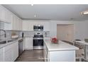 Modern kitchen featuring white cabinets, stainless steel appliances, and a stylish backsplash at 3801 E Captain Dreyfus Ave, Phoenix, AZ 85032