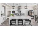Spacious kitchen boasts a large island, white cabinets, and modern pendant lighting at 23120 W Skinner Rd, Wittmann, AZ 85361