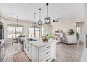Open concept kitchen with white island, stainless steel appliances, and wood-look floors at 23120 W Skinner Rd, Wittmann, AZ 85361