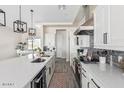 Modern kitchen with white cabinets, long countertops, and gray backsplash at 23120 W Skinner Rd, Wittmann, AZ 85361