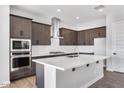 Stylish kitchen featuring stainless steel appliances, an island, and modern lighting at 14189 W Sand Hills Rd, Surprise, AZ 85387