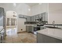 Bright kitchen with gray cabinetry, stainless steel appliances, and mosaic tile backsplash at 5249 E Hobart St, Mesa, AZ 85205