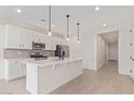 Island kitchen with white cabinets and quartz countertops at 17845 W Blue Sky Dr, Surprise, AZ 85387