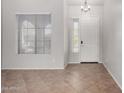 Bright foyer featuring neutral paint, tile flooring, and a front door with sidelight windows at 2140 W Clearview Trl, Anthem, AZ 85086