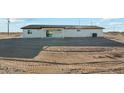 Backyard view of the covered patio on a single-story home with minimal landscaping at 31812 N 221St Dr, Wittmann, AZ 85361