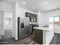 Modern kitchen with stainless steel appliances, granite countertops, and wood-look flooring at 24579 W St Catherine Ave, Buckeye, AZ 85326