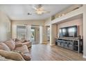 Cozy living room features neutral colors, wood floors, recessed lighting, and sliding glass door to backyard at 1448 E Poncho Ln, San Tan Valley, AZ 85143