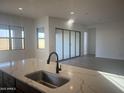 Kitchen island with sink, quartz countertop, and view into living area at 908 W Superstition Dr Dr, Queen Creek, AZ 85140