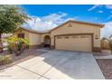 Tan house with a two-car garage and driveway at 18009 W Ivy Ln, Surprise, AZ 85388