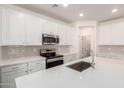 Modern kitchen boasts white cabinets, stainless steel appliances, and quartz countertops at 18162 W Cielo Grande Ave, Surprise, AZ 85387