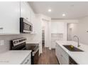 Bright kitchen features white cabinets, stainless steel appliances, and tile backsplash at 18162 W Cielo Grande Ave, Surprise, AZ 85387