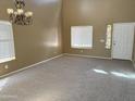 Spacious living room with new carpet, a chandelier, and plenty of natural light from windows at 29101 N Yellow Bee Dr, San Tan Valley, AZ 85143