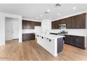 Open kitchen with an island, stainless steel appliances, and modern cabinetry at 10864 E Texas Ave, Mesa, AZ 85212