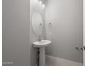 Bathroom featuring a pedestal sink, an oval mirror, and tile floors at 7691 W Cactus Wren Way, Florence, AZ 85132
