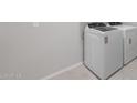 Bright laundry room with a modern washer and dryer on a tile floor at 7691 W Cactus Wren Way, Florence, AZ 85132