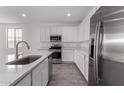 Well-equipped kitchen featuring stainless steel appliances, white cabinets, and elegant quartz countertops at 12333 W Marguerite Ave, Avondale, AZ 85323
