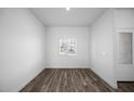 A bedroom featuring wood flooring, a window, and white walls, creating a simple, clean space at 24629 W St Catherine Ave, Buckeye, AZ 85326