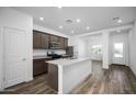Bright, open kitchen featuring stainless steel appliances, wood flooring, a center island, and granite countertops at 24629 W St Catherine Ave, Buckeye, AZ 85326
