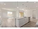 Open-concept kitchen with a large island and pendant lighting, flowing into the adjacent living space at 11949 W Parkway Ln, Avondale, AZ 85323