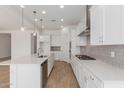 Bright kitchen features white cabinets, stainless appliances, quartz countertops, and wood-look floors at 12003 W Parkway Ln, Avondale, AZ 85323