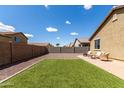 A spacious backyard features low-maintenance landscaping, artificial turf, and a paved patio area at 18147 W Ida Ln, Surprise, AZ 85387